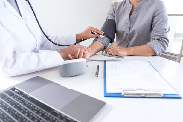 istock Doctor using a measuring blood pressure checking patient with examining, presenting results symptom and recommend treatment method, Healthcare and medical concept 1238007748