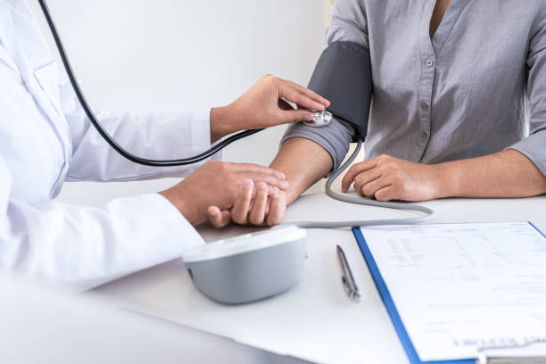 istock Doctor using a measuring blood pressure checking patient with examining, presenting results symptom and recommend treatment method, Healthcare and medical concept 1238007750