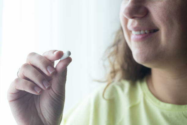 istock Woman putting supplements in mouths. 1238008701