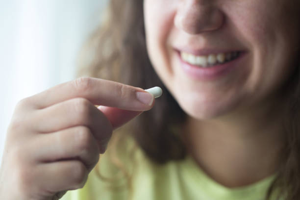 istock Woman putting supplements in mouths. 1238008715