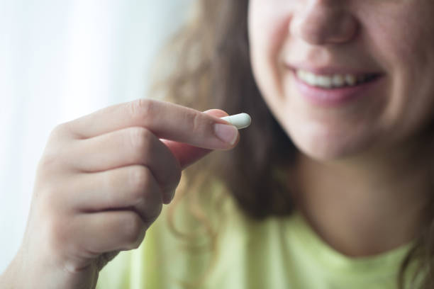 istock Woman putting supplements in mouths. 1238008745
