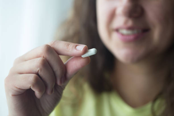 istock Woman putting supplements in mouths. 1238008763