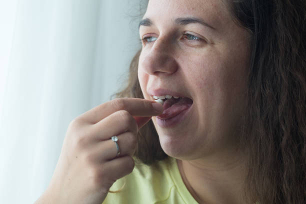 istock Woman putting supplements in mouths. 1238008807