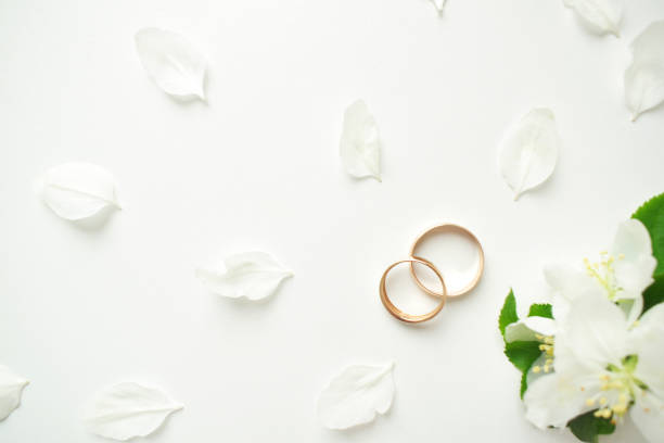 istock Wedding ring. On a white background and with delicate white flowers. Wedding symbols and attributes 1238046049