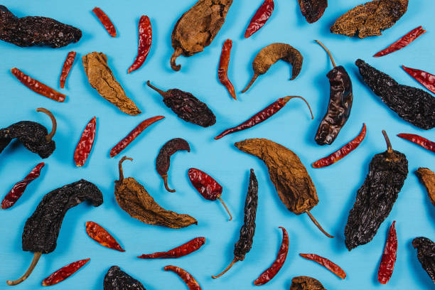 сушеный красный перец чили и специи порошка чили на синем фоне в мексике вид сверху - pepper spice dried plant image стоковые фото и изображения