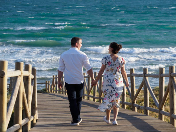 istock Two young lovers enjoying a walk together to the sea 1238071268