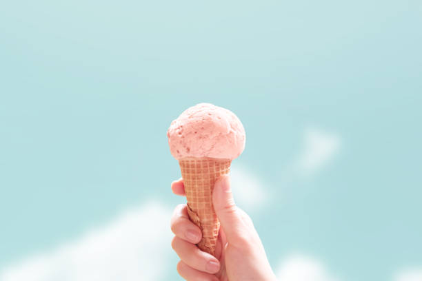 Young woman hands holding ice cream cones on sky summer background