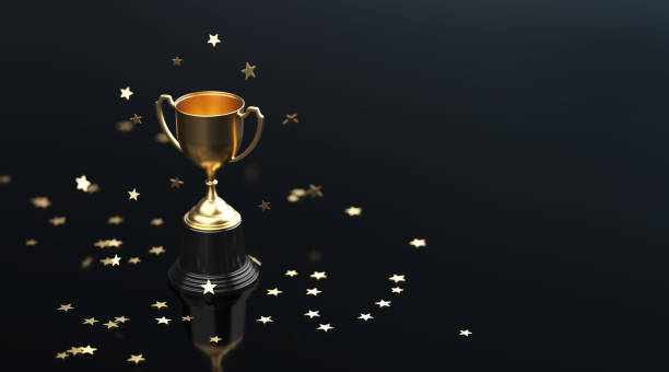 istock Star Shaped Confetti Falling over Gold Cup Sitting on Black Background 1238080830