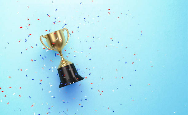 colorful confetti falling over gold cup sitting over blue background - campeonato ilustrações imagens e fotografias de stock