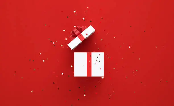 Photo of Star Shaped Confetti Falling Over Open White Gift Box Tied With Red Ribbon