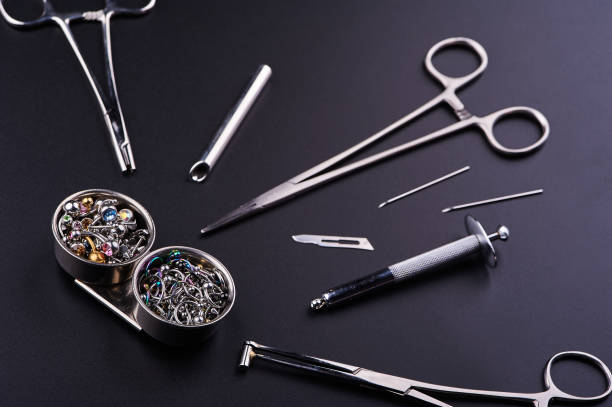 istock instrument for piercing, clips lying next to with earrings on a black background 1238106998