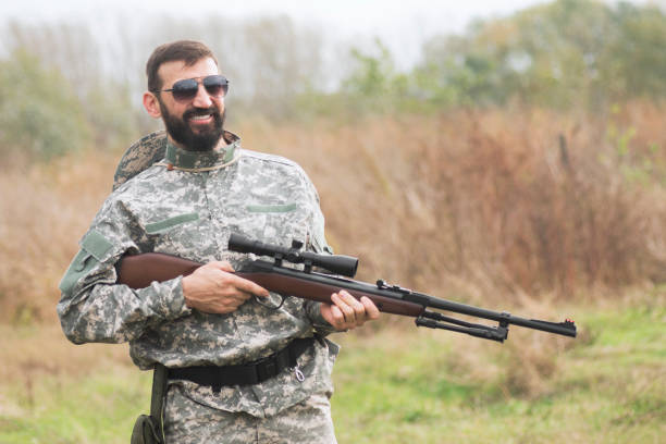 istock smiling soldier with shotgun weapon 1238109577