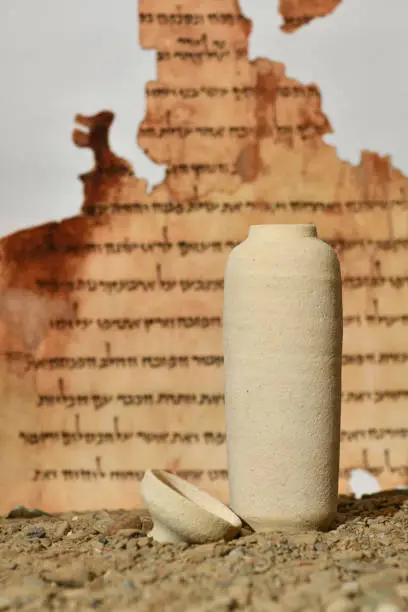 A model of a Jar used for the Dead Sea scrolls against a blurred background of the Isaiah scroll