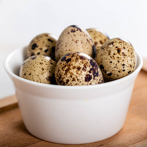 istock Quail eggs in white bowl on wooden background 1238148485