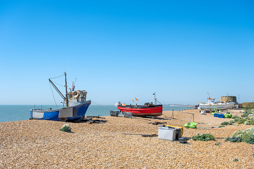 Fishing boats pulled up on to the shingle beach at Hythe, Kent, UK