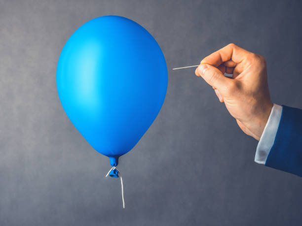 Blue balloon. Man hold needle directed to air balloon. Concept of risk. Copy space stock photo