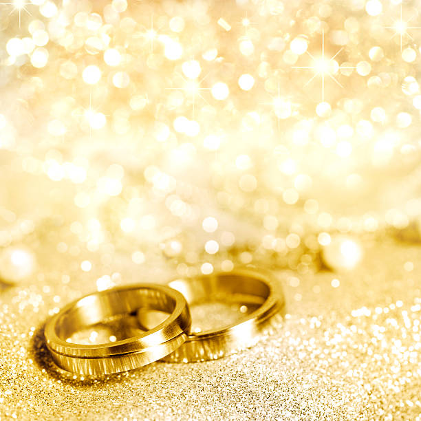 Gold wedding rings with glittering gold background Wedding rings in gold and pearls funkeln stock pictures, royalty-free photos & images