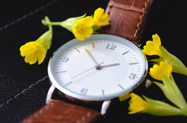 istock Clock on a black background with yellow flowers. 1238202513