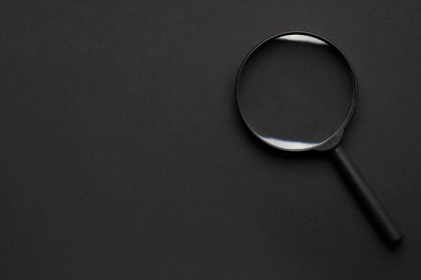 search concept. black on black. magnifier on dark background. view from above. copy space for design.