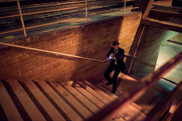 Careful police officer holding a gun while chasing his target Secret service agent in pursuit of criminals while leaving an underground subway man holding gun at night in the city stock pictures, royalty-free photos & images