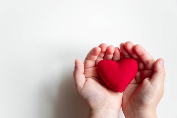 istock Close up child hand holding red heart on light background top view with copy space 1238251389