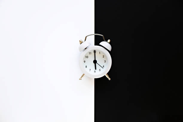 istock Alarm clock on black and white background. White vintage alarm clock on minimalistic background. Minimal thing. Minimal think 1238251914