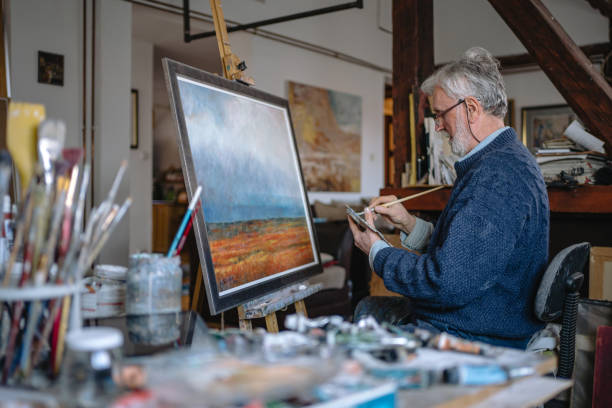 Senior man painting a peaceful field