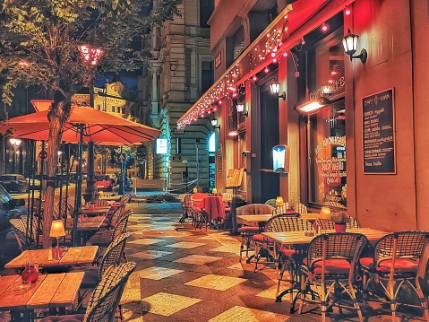 Budapest, Hungary - May 24th, 2020: Empty outdoor seating at a popular sidewalk café in Budapest at night. Taken just as Budapest reopened from the coronovirus pandemic of 2020