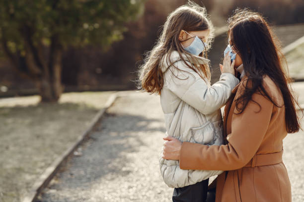 istock Mother with daughter walks outside in masks 1238293155