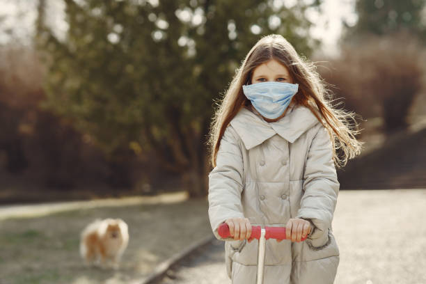 istock Little child walks outside in a mask 1238293683