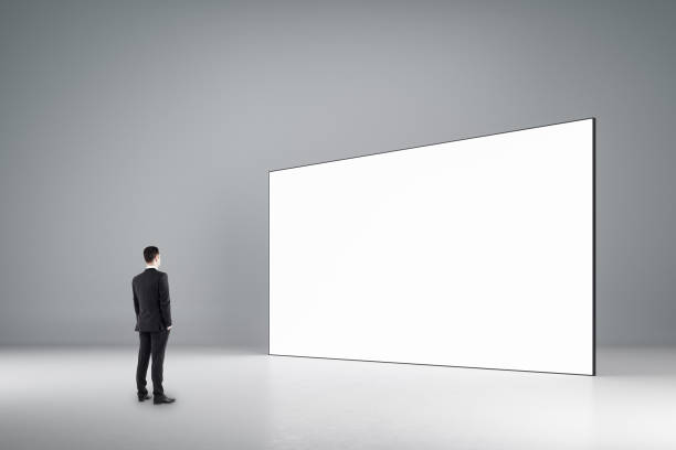 istock Businessman looking at empty billboard in room 1238298931