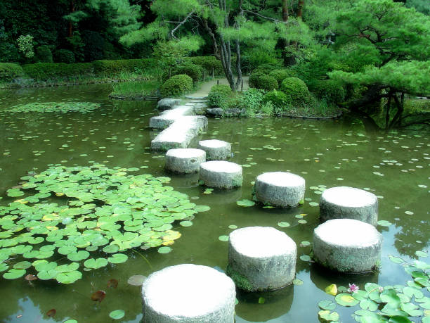 The Japanese style garden at Heian Shrine was created over a 20 year period by Ogawa Jihei VII, a renowned Japanese garden architect of the Meiji era and Taishō era.  This garden is quite famous for its array of weeping cherry trees, which bloom several days later than most other cherry trees, typically in mid-April.  The horizontal photograph that you are viewing here was captured in September of 2007.  It features cylindrical stepping stones that were arranged by Ogawa Jihei VII in such a way so that visitors stepping on them can feel as if they might be riding on a dragon.
