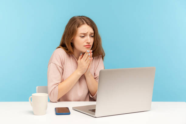 istock Please, begging for help! Young woman employee holding hands in praying gesture and talking on video call 1238327809