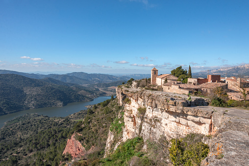 View of the church of Siurana, with the lake in the background in Catalonia, Spain.
