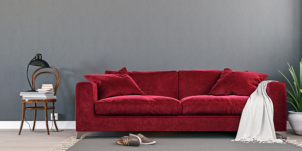 Black toy velvet couch on red background. Credit card. Shopping from home concept.