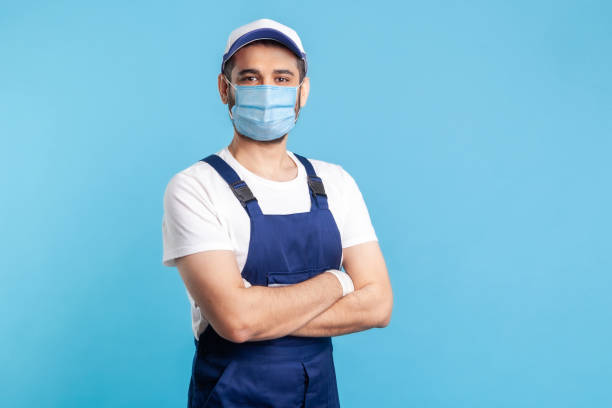 retrato de faz-tudo feliz em macacão e boné de pé com as mãos cruzadas, profissão da indústria de serviços - coveralls professional occupation manual worker service occupation - fotografias e filmes do acervo