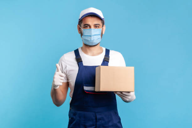 istock Cargo transportation, good delivery service. Satisfied courier in uniform holding cardboard box 1238385172