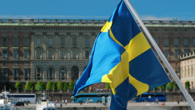Stockholm, Sweden. Waving Swedish Flag In Stockholm Street