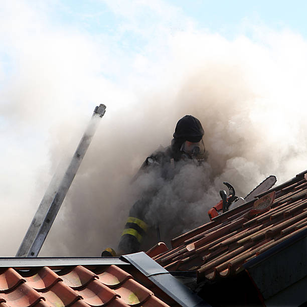 istock Firefighter on roof of house fire 123844341