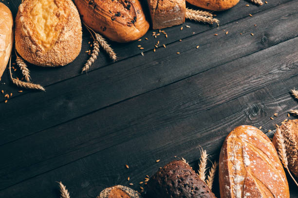 istock Bread border on wood background with copy space.Different types of bread arranged as frame with spikelets. Bakery, cooking and grocery store concept. 1238482326