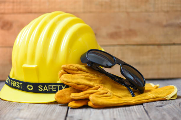 istock Safety equipment standard construction safety - Industrial protective workwear tool with yellow hat safety helmet glasses and gloves on wood background 1238556548