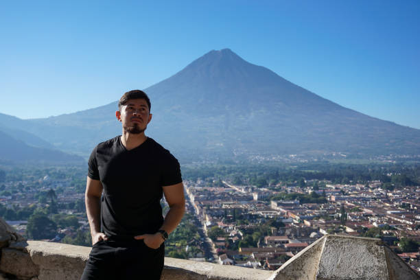 istock Young man posing with water volcano and ancient city 1238567455