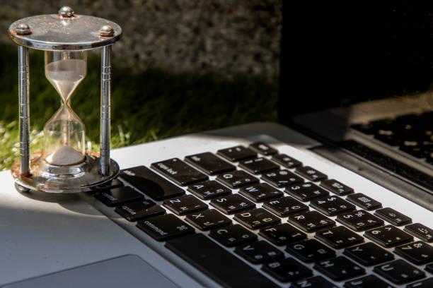 istock Hourglass on laptop keyboard. Time management concept. 1238597400