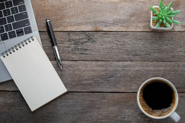 istock Top view from above of Blank open notebook, keyboard with glasses and coffee cup on wood table background. Workplace creative at home. Flat lay, Business-finance or education concept with copy space. 1238636072