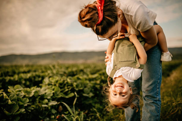 istock Mother having fun with daughter in strawberry field 1238642473