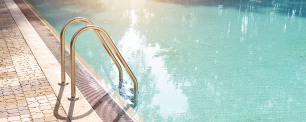 istock Big luxury empty rectangular swimming pool with clean blue water and ladder at tropical forest beach resort at sunrise morning light and nobody outdoors. Healthy leisure lifestyle travel and exercise 1238682557