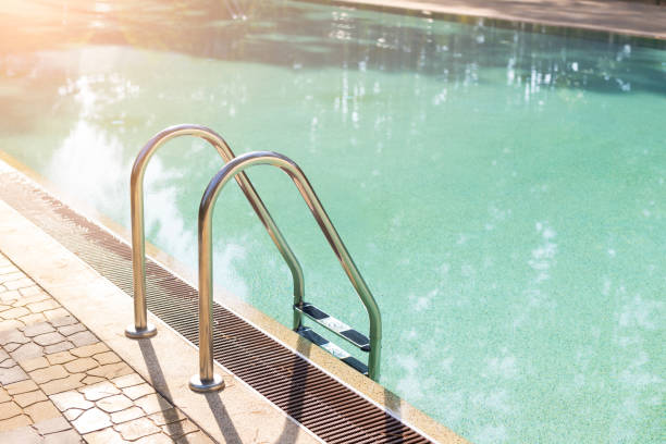 istock Big luxury empty rectangular swimming pool with clean blue water and ladder at tropical forest beach resort at sunrise morning light and nobody outdoors. Healthy leisure lifestyle travel and exercise 1238682992
