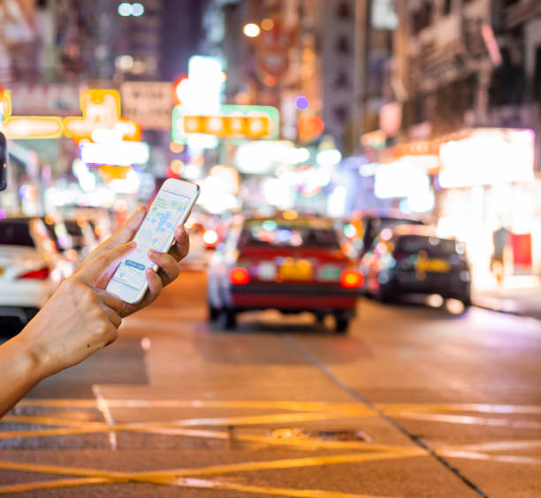 istock Hands holding cell phone with map on screen in front traffic at night 1238716501