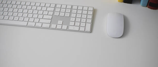 istock Simple office desk with computer devices, books and copy space on white table 1238770491