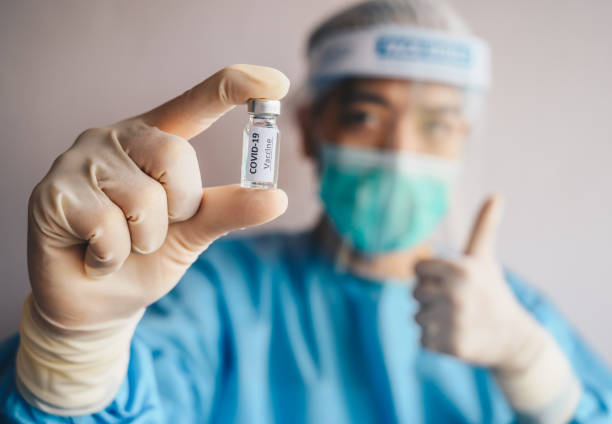 Scientist doctor holding a sample test bottle of Covid-19 vaccine and showing thumb up. Vaccination is one of the most effective ways to prevent diseases and helps the body’s immune system from virus. illness prevention photos stock pictures, royalty-free photos & images